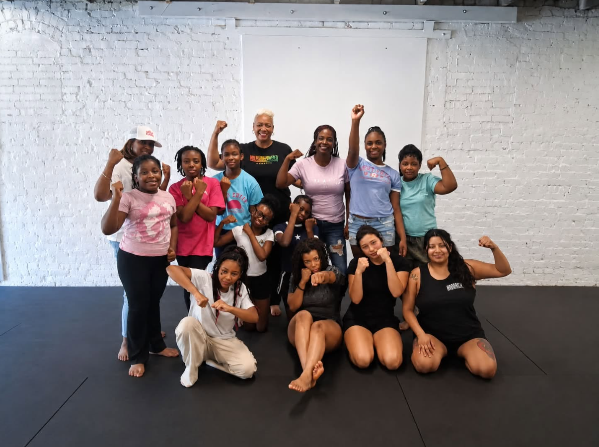 Girls and mentors flexing after self-defense class